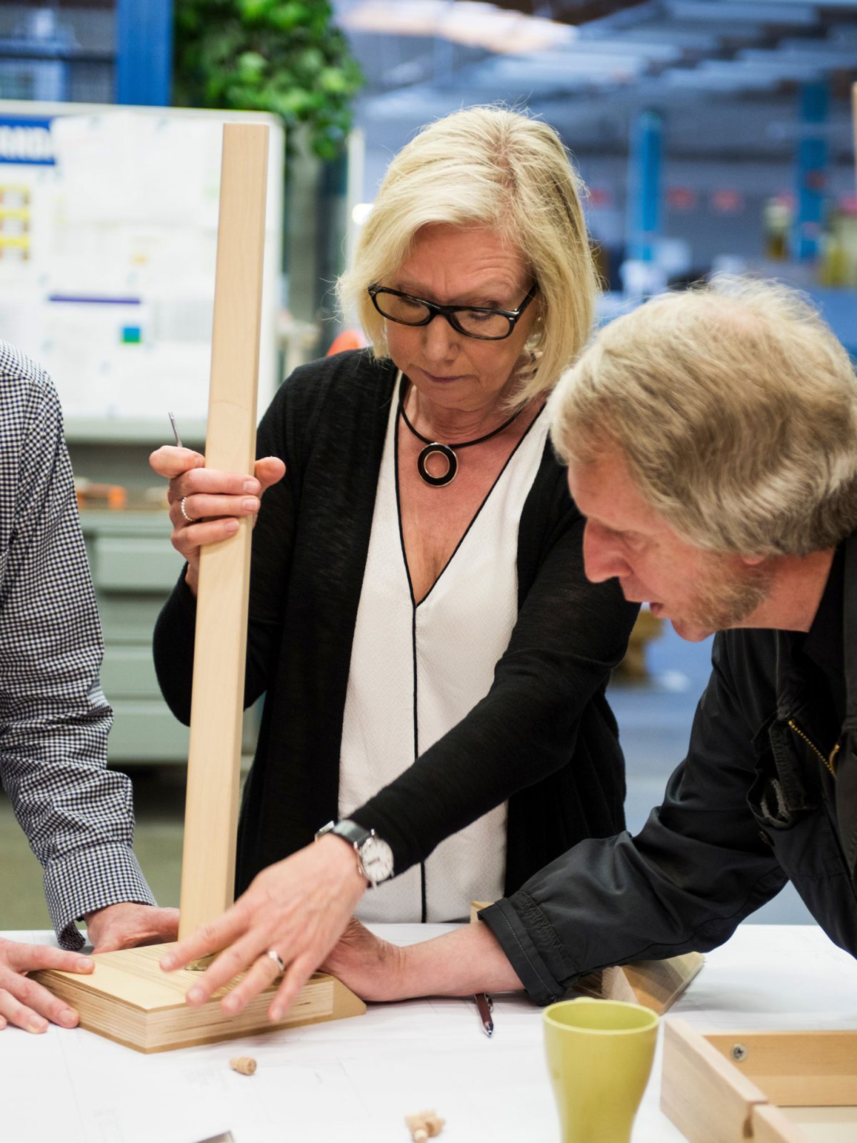 Blond man and woman working with a table in a workshop.