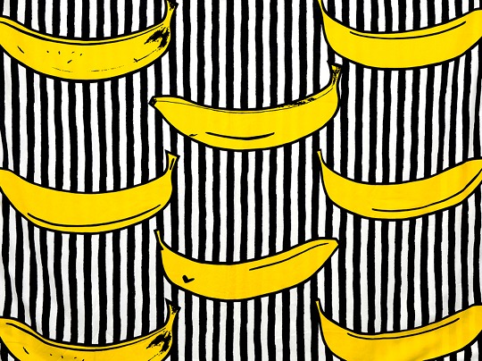 Fabric pattern RANDIG BANAN in which yellow bananas are printed on black and white stripes.