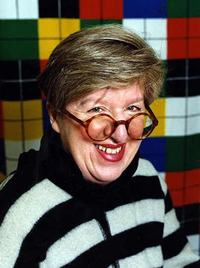 Smiling grey-haired woman, Inez Svensson, with round glasses and striped sweater.