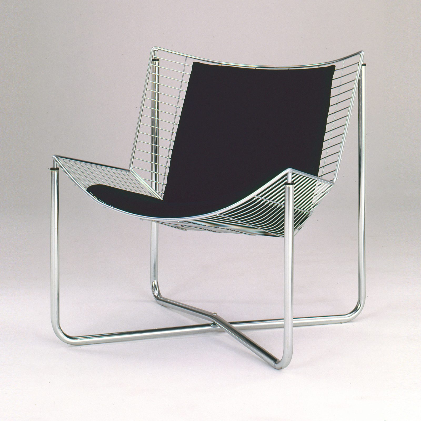 Black armchair made of steel mesh and chrome pipes.