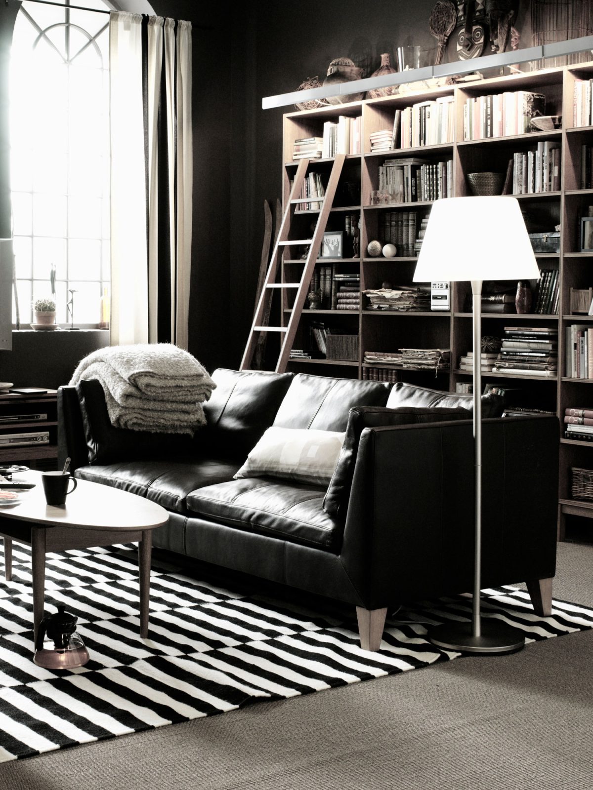 Simple black leather sofa in stylish living room.