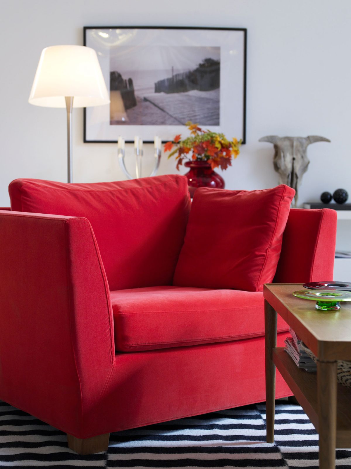 Red armchair on striped rug.