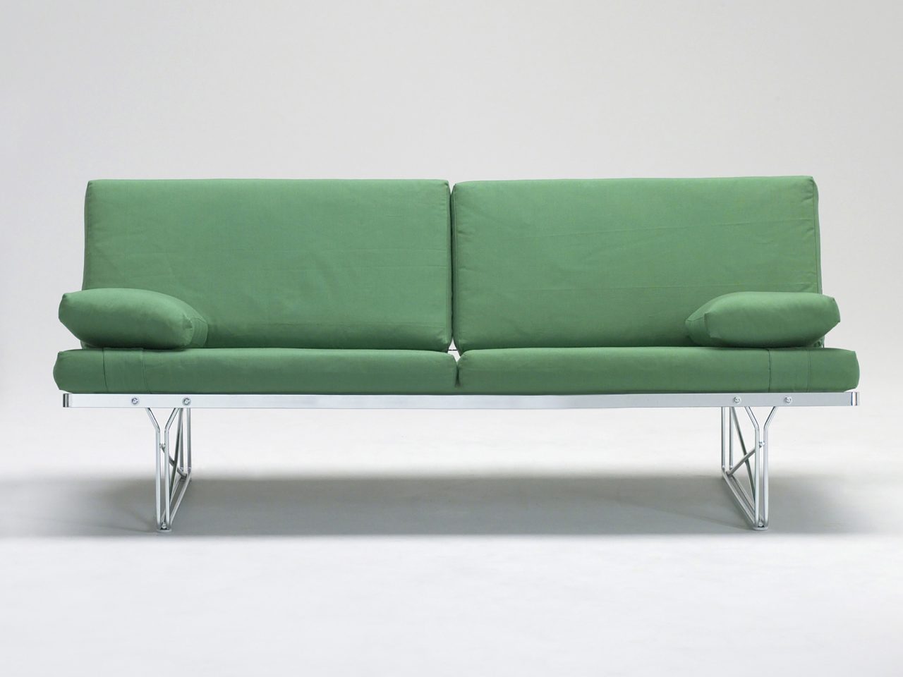 A sleek, simple green sofa rests on a steel frame.