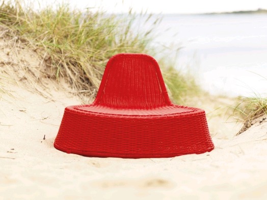 Red lounge chair standing on a sandy beach, VÄNÖ.