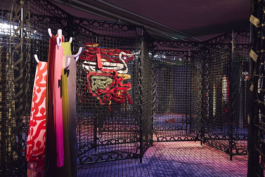 A room with nets where ribbons are woven through in different patterns.