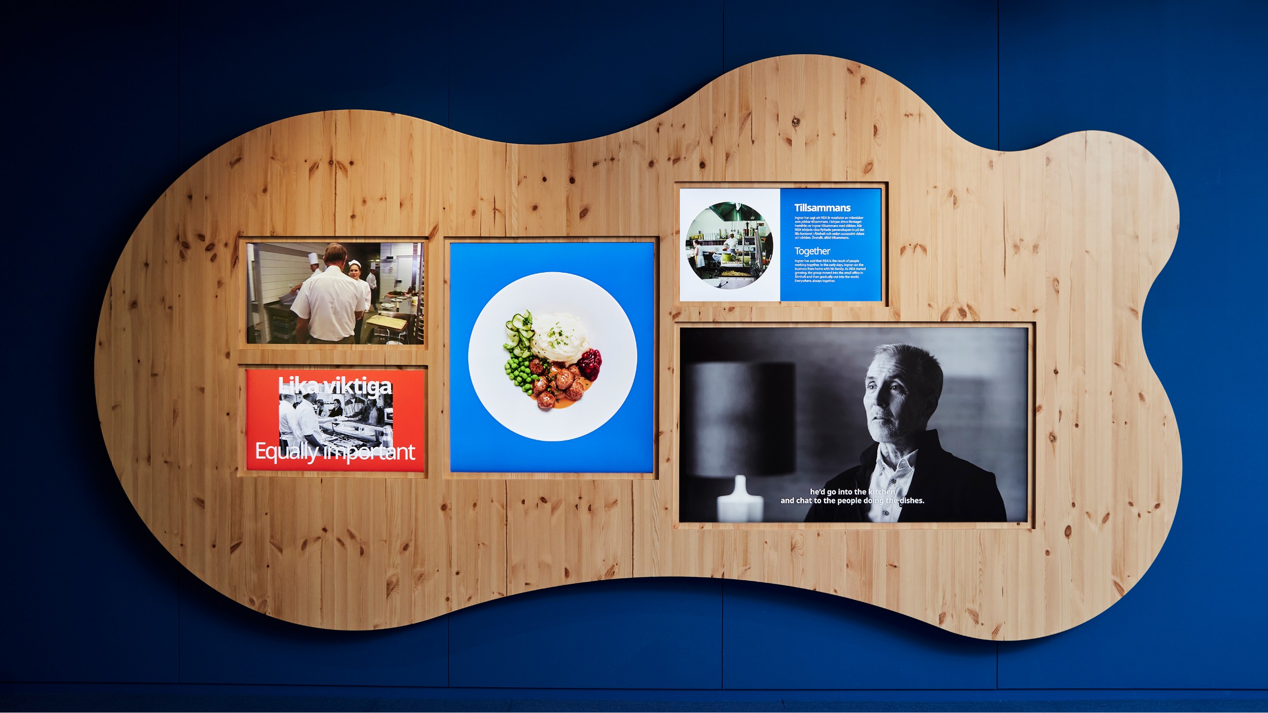 Exhibition wall in wood with images and texts about IKEA, focusing on food, co-workers and togetherness