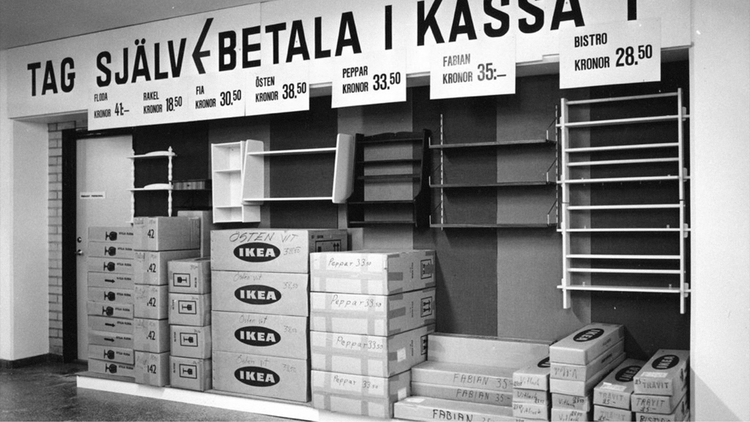 IKEA self-service warehouse with shelves and flat-pack boxes, with sign to pay at the checkout