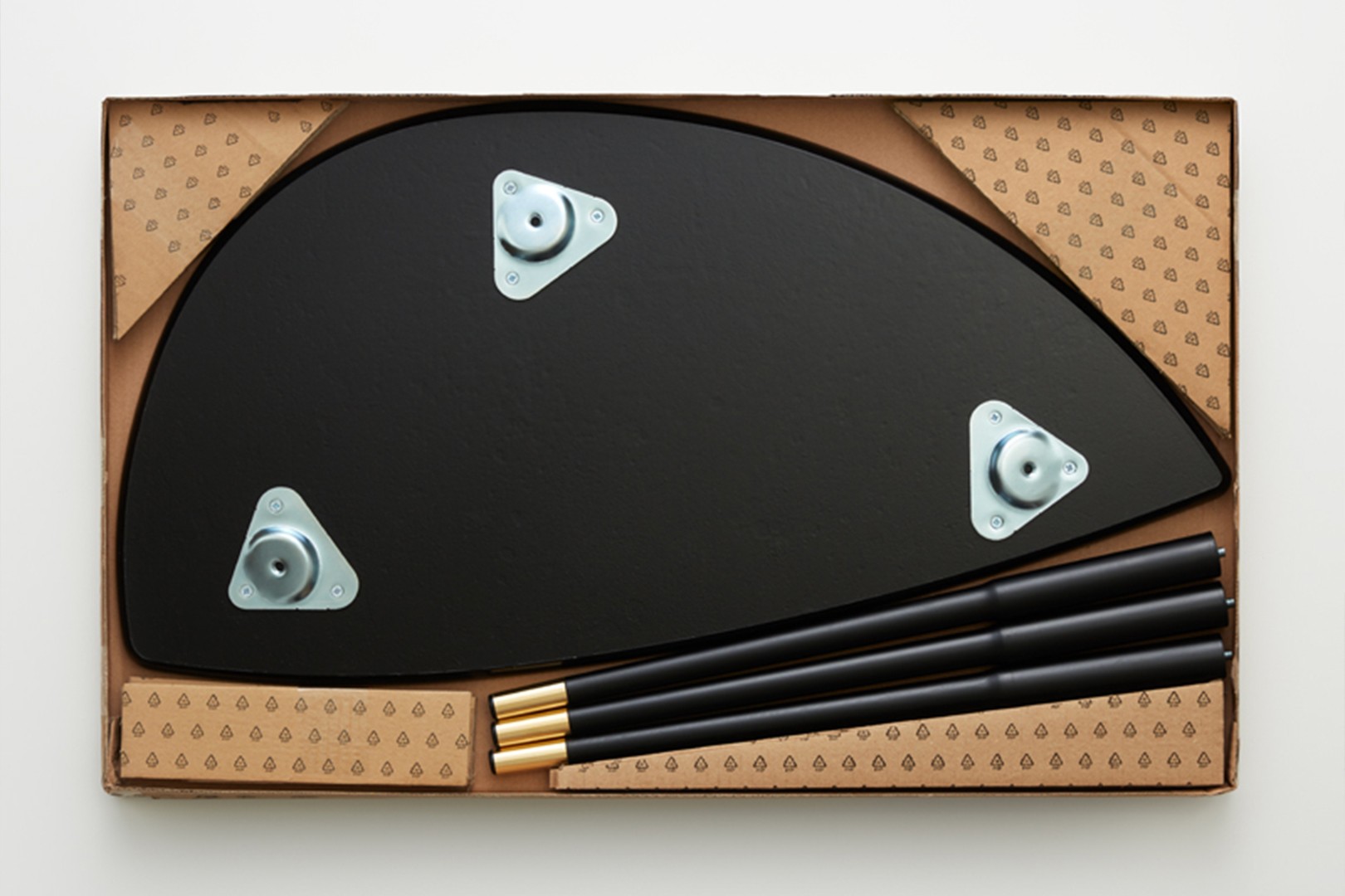 Flat pack furniture parts in a box, including tabletop and legs ready for assembly