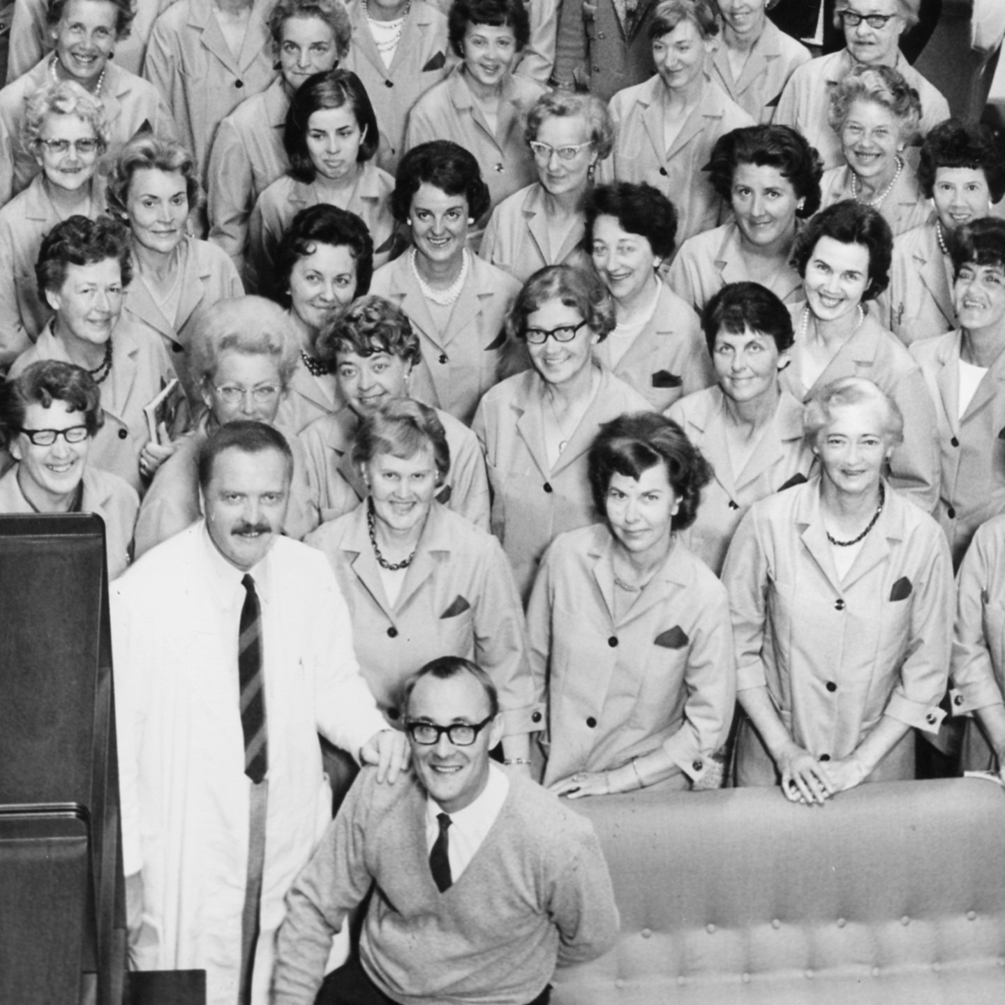 Group photo of co-workers in workwear gathered together, with Ingvar Kamprad seated in the front
