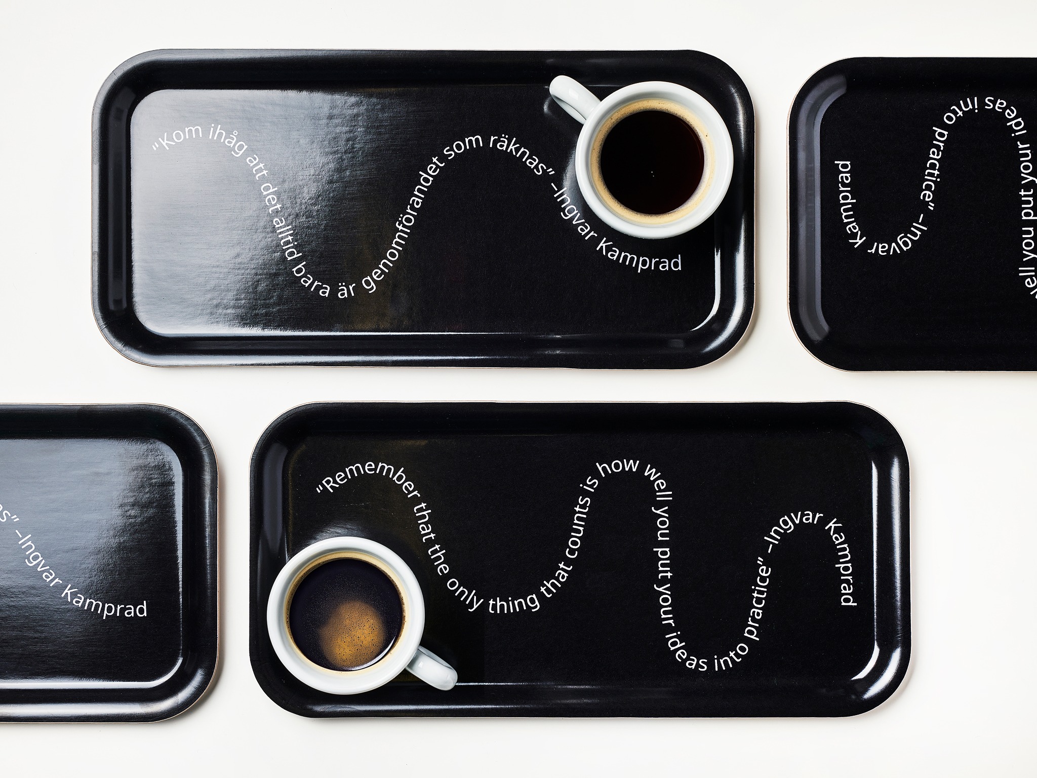 Svarta smala brickor som bär kaffekoppar.